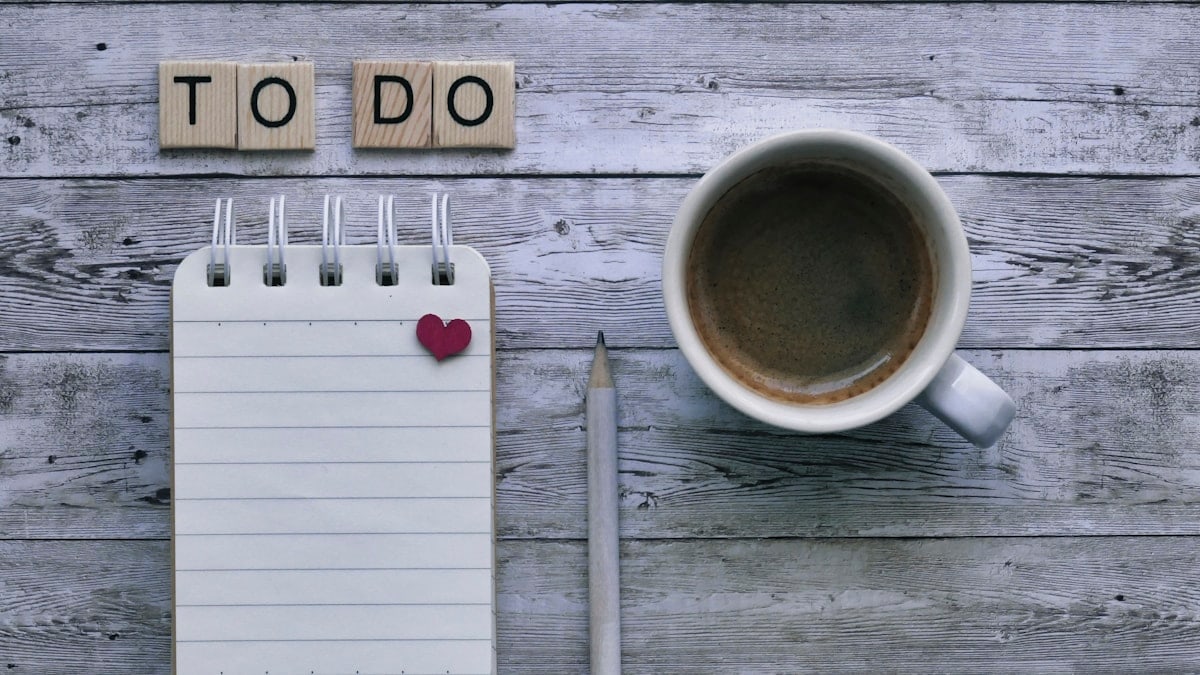 To do list, coffee, and pencil on wooden background